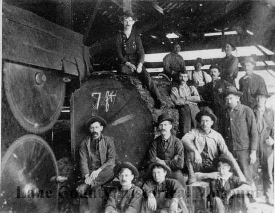 Millworkers pose with log inside Booth Kelly sawmill building, 1900